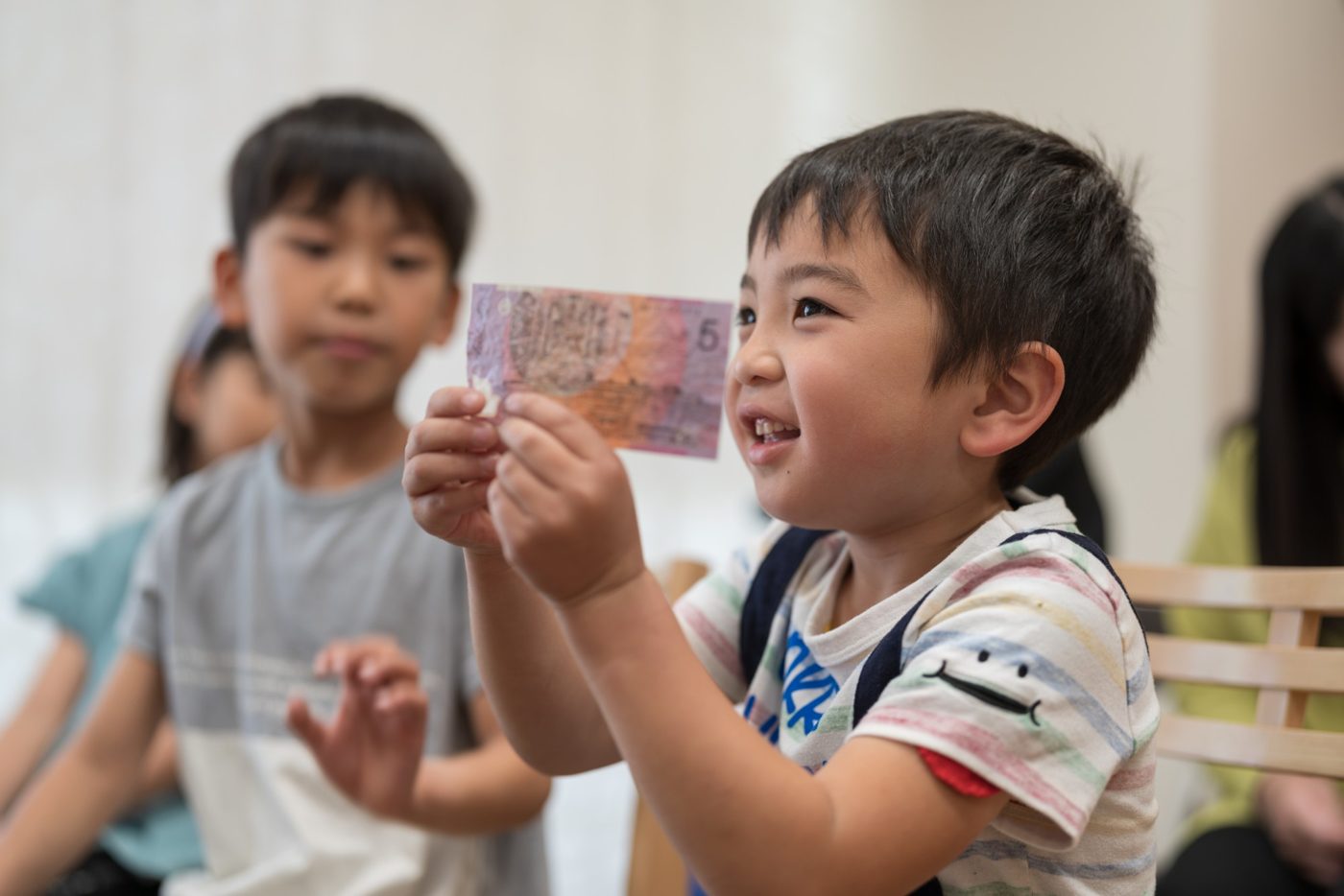 お札を持ってうれしそうな男の子